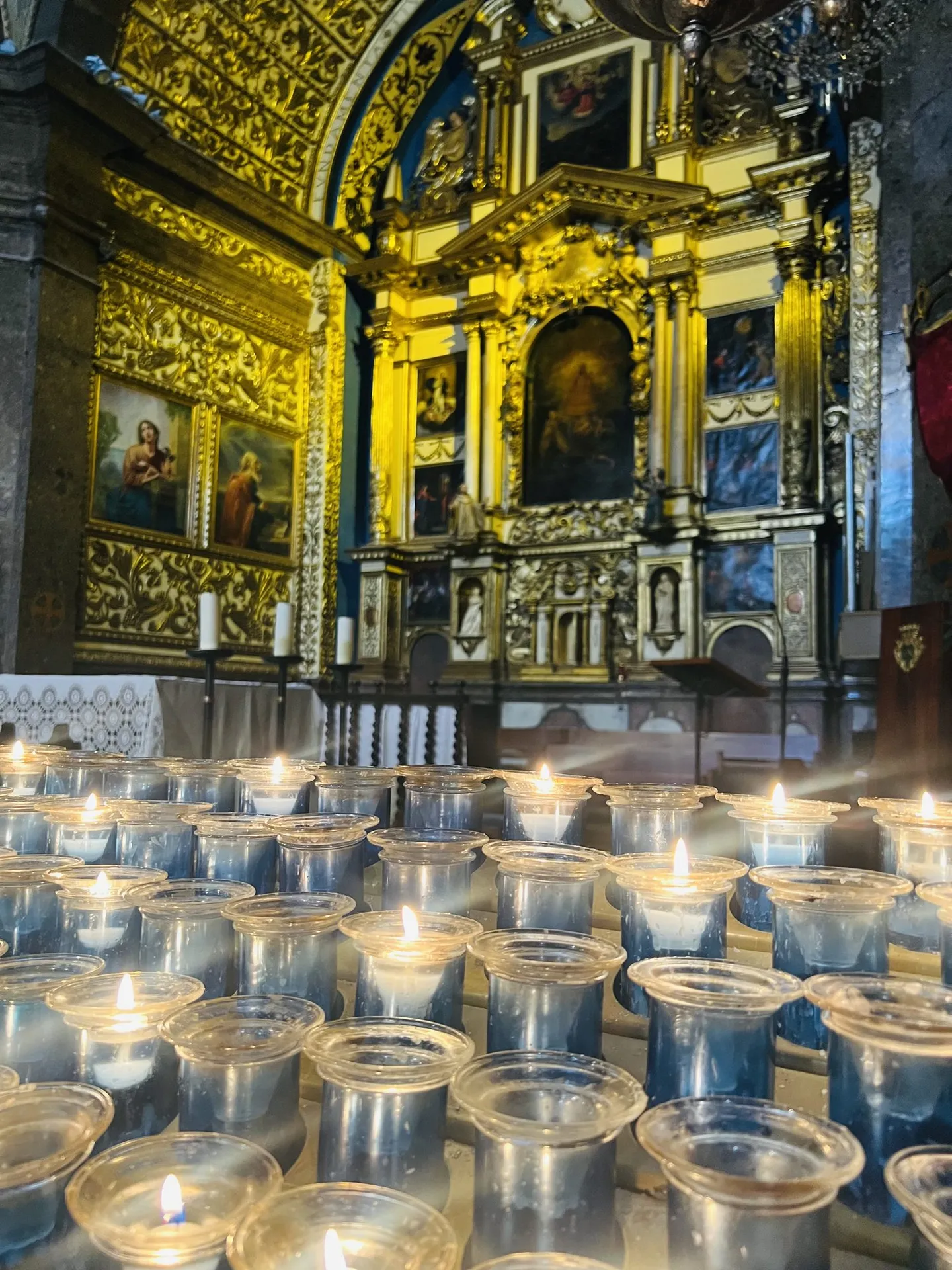 Goldener Altarraum der Basilika von Lluc mit vielen Opferkerzen.