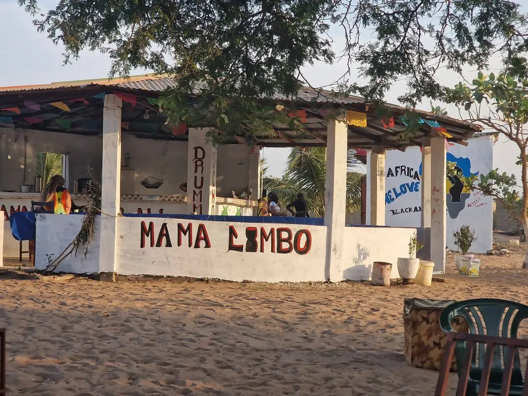 Das Strandlokal Mama Limbo in Sanyang mit bunter Wimpelkette unter Bäumen