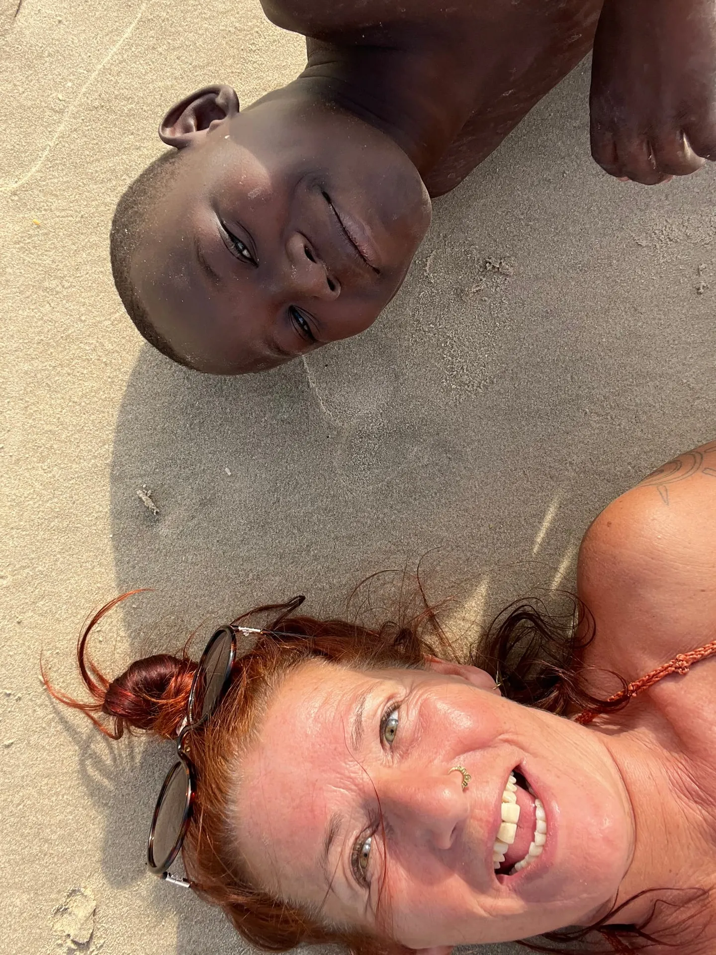 Marion lachend mit einer Freundin im warmen Sand