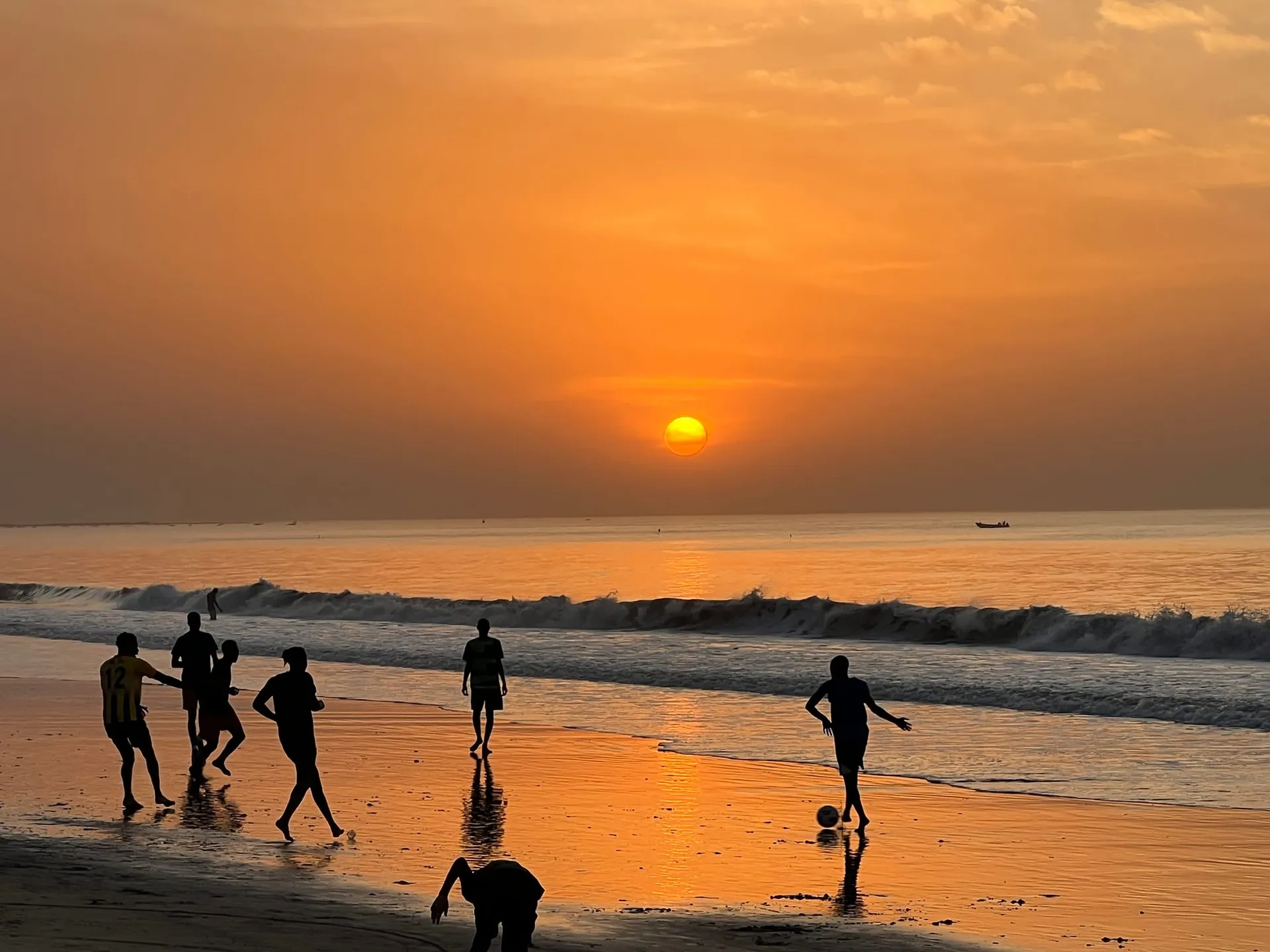 Menschen als Silhouetten im goldenen Abendlicht am Strand von Sanyang