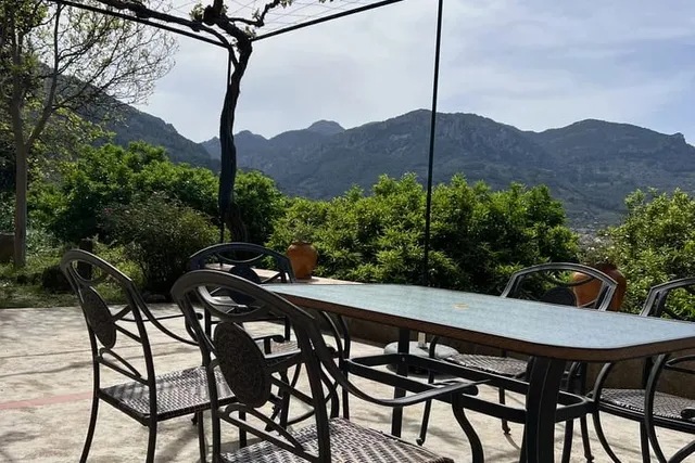 Terrasse mit Tisch und Stühlen und weitem Blick auf die Berge des Tramuntana-Gebirges