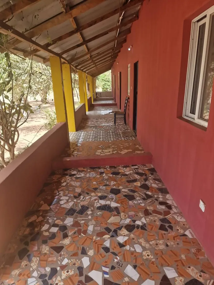 Überdachte Veranda der Unterkunft mit farbenfrohem Mosaikboden in Sanyang